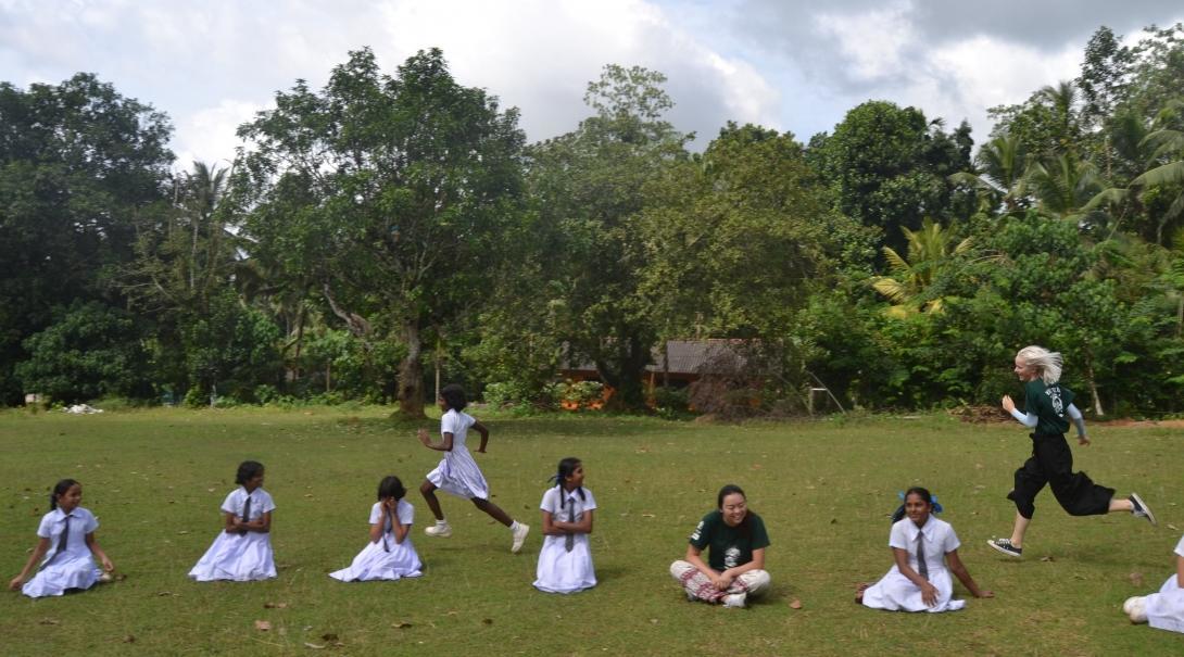 A Projects Abroad volunteer gains sports coaching work experience in Sri Lanka running an exercise with children An instructor volunteers as a sports coach in schools in Sri Lanka and works with children